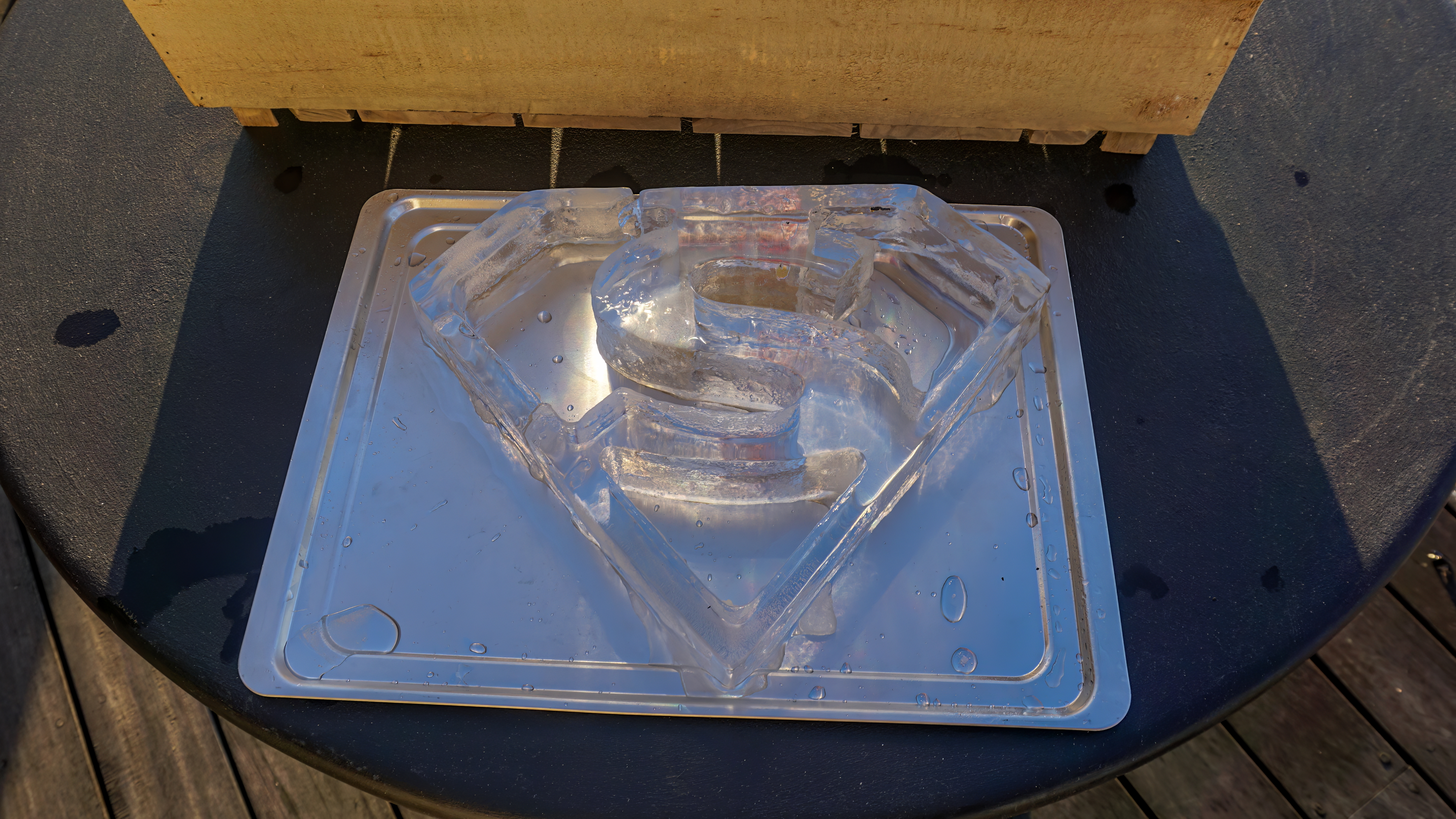 Crystal-clear ice orb in glass showing minimal surface area for slow melting